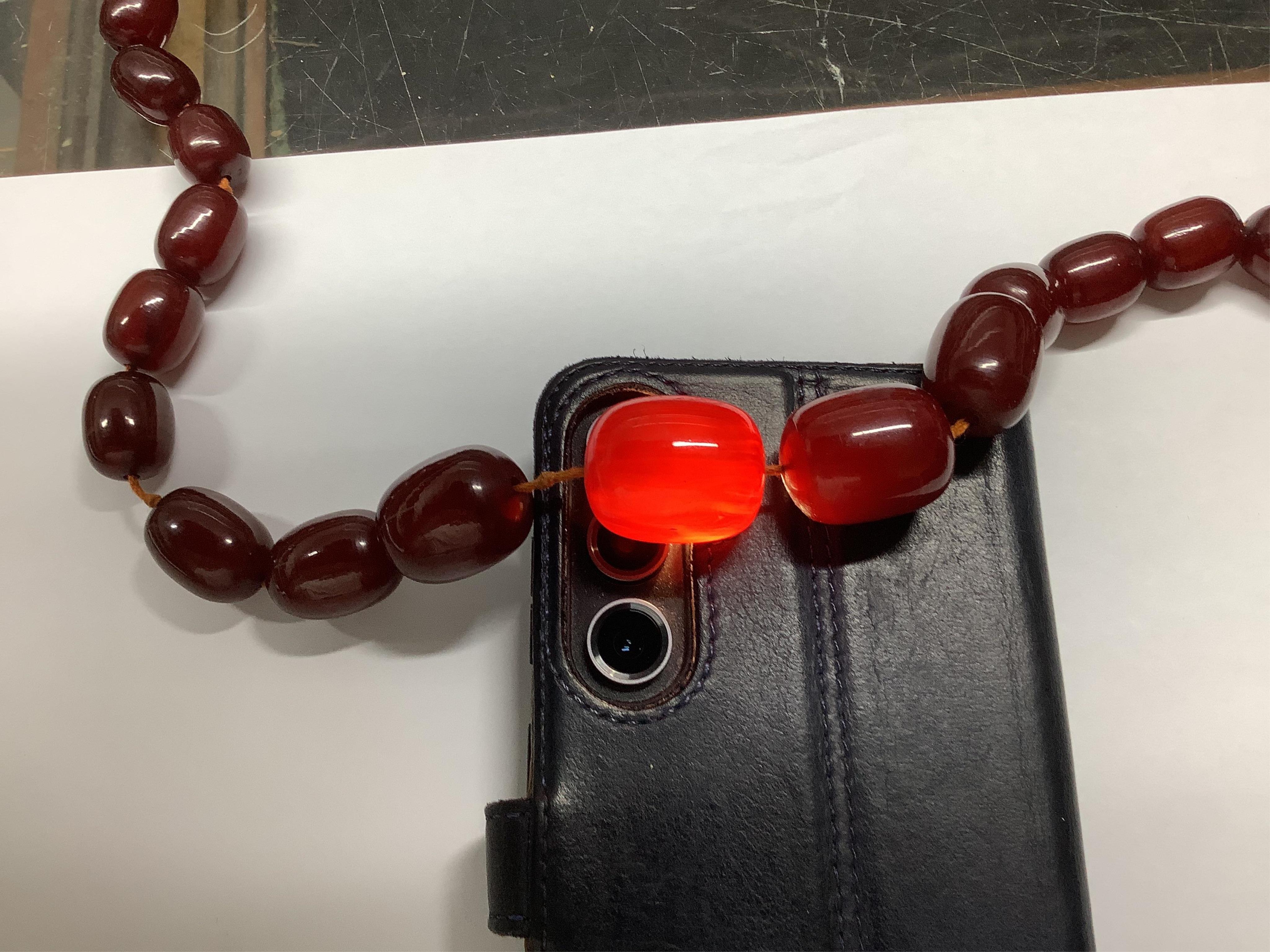 A single strand graduated simulated cherry amber necklace, 68cm gross weight 108 grams, Condition - fair